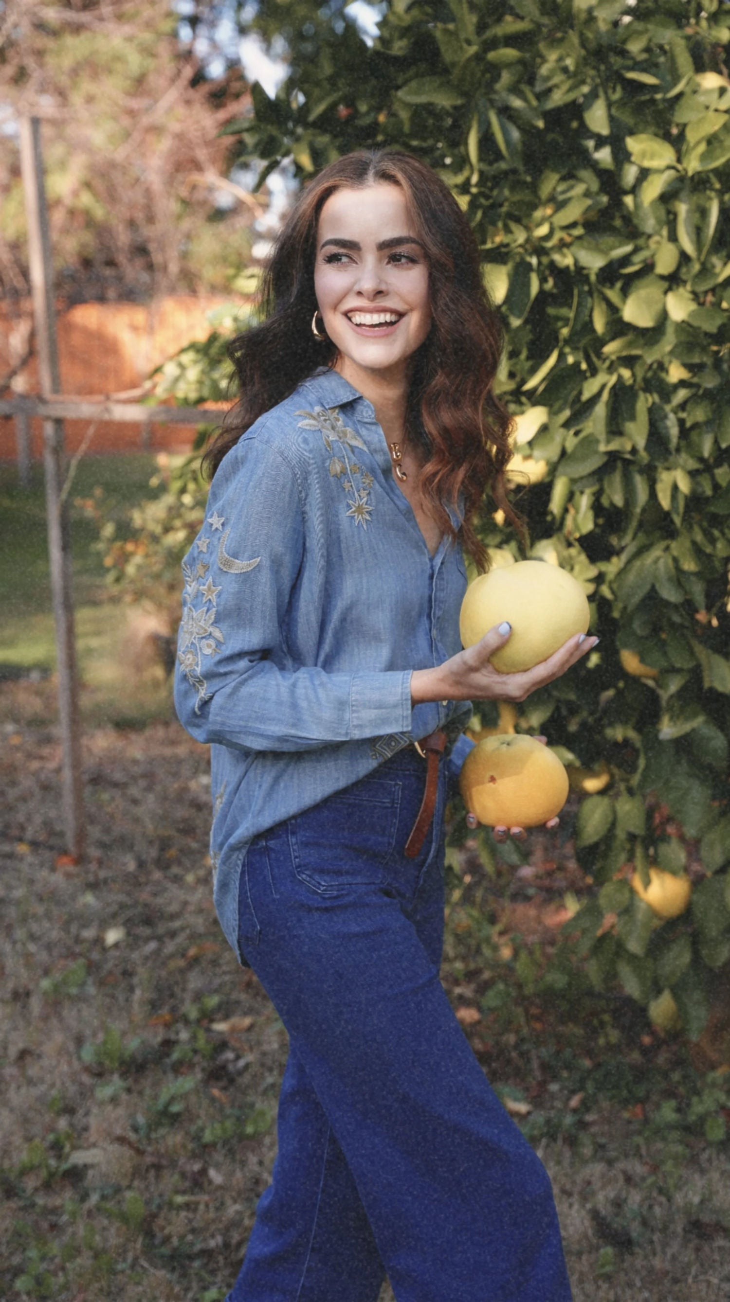 Person holding a jar of cream with a blurred green field background